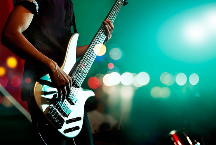A closeup of a bass guitar player.